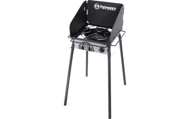 Schwarz-silberner einflammiger Kocher auf vier Beinen mit dreiseitigem Windschutz, runder Brenner, Metallrost, vorderer Drehknopf und sichtbarer Petromax-Schriftzug