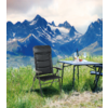 Berglandschaft mit schneebedeckten Gipfeln, Wiese im Vordergrund, ein Klappstuhl und ein Tisch mit einer Wasserflasche und einem Glas