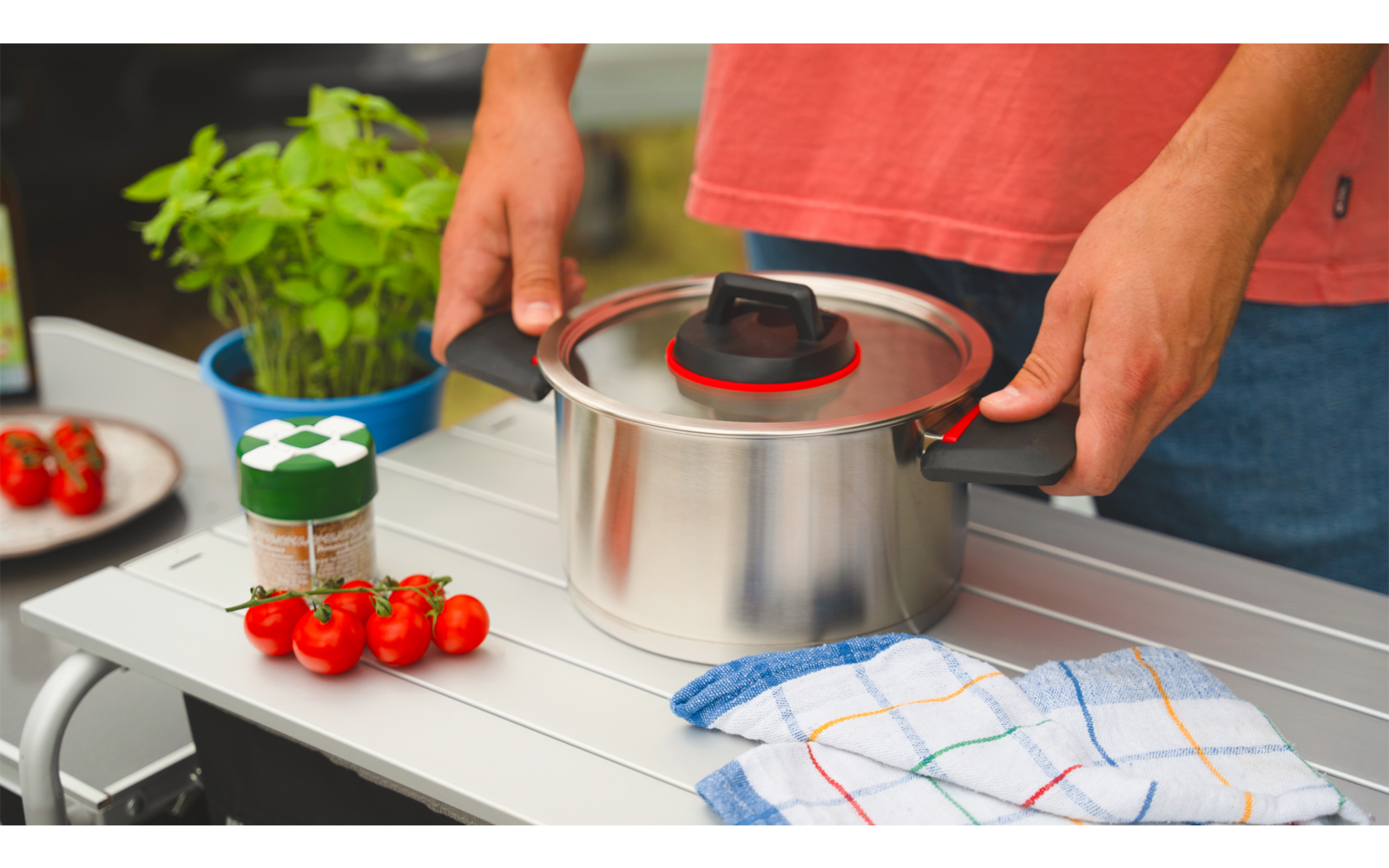 Personne posant une casserole sur une table blanche avec des cubes et des épices