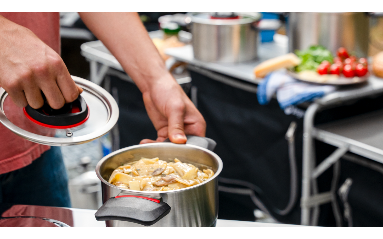 Main versant de l'huile dans une casserole avec de la nourriture dans une cuisine