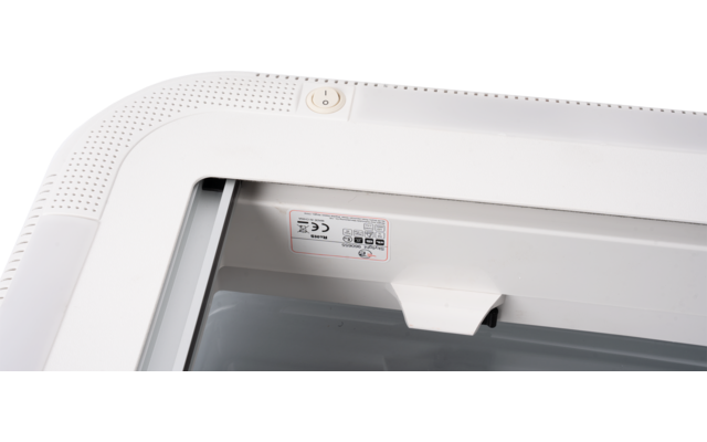 Rounded white frame with perforated surface, round button at the top, small sticker with symbols and text, transparent window showing interior and triangular white inner component