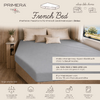 Bed met grijs hoeslaken, drie beige kussens, houten zijwand met plank en vaas, raam met landschap, zichtbare productteksten en merknamen 'French Bed' en 'PRIMERA TRAVEL' en pictogrammen