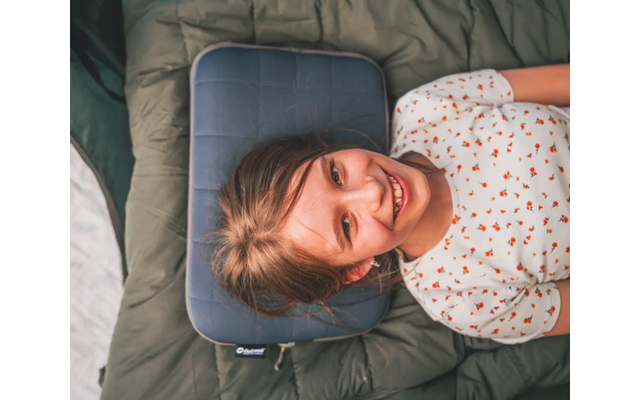 Ragazza sorridente sdraiata su un materassino gonfiabile da campeggio