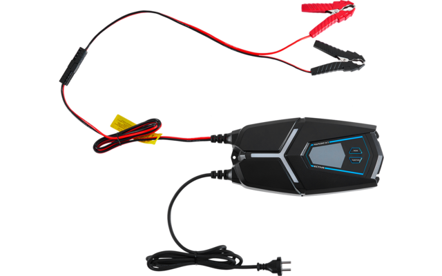 Schwarzes elektronisches Gerät mit grauen und blauen Akzenten, daran rote und schwarze Krokodilklemmen, gelbe Etiketten und ein Netzstecker