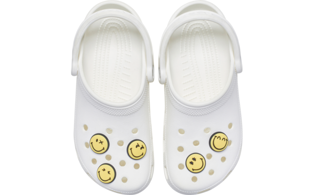 Paire de sabots blancs vue de dessus, trous d'aération, brides au talon, quatre décorations rondes jaunes avec traits de visage noirs