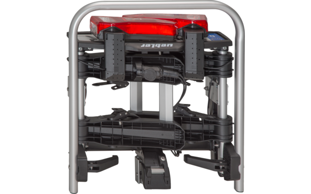 Zusammengeklappter Fahrradträger mit silbernem Metallrahmen, schwarzen Kunststoffteilen und rotem Rücklicht oben