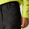 Nahaufnahme der Hüftpartie einer Person in schwarzen Hosen mit Regatta-Label und neon-gelbem Fleecepullover; rechte Hand sichtbar