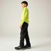 Kind seitlich stehend, trägt neongrünes Langarmshirt, schwarze Cargohose und schwarze Sportschuhe vor einfarbig hellem Hintergrund