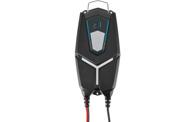 Schwarzes Kunststoffgehäuse mit Metallgriff oben, blau-weißem geometrischem Zierelement auf der Vorderseite, zwei kleinen rechteckigen Öffnungen oben und roten sowie schwarzen Kabeln, die unten herausführen