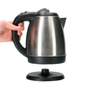 Hand holding an electric kettle above the base