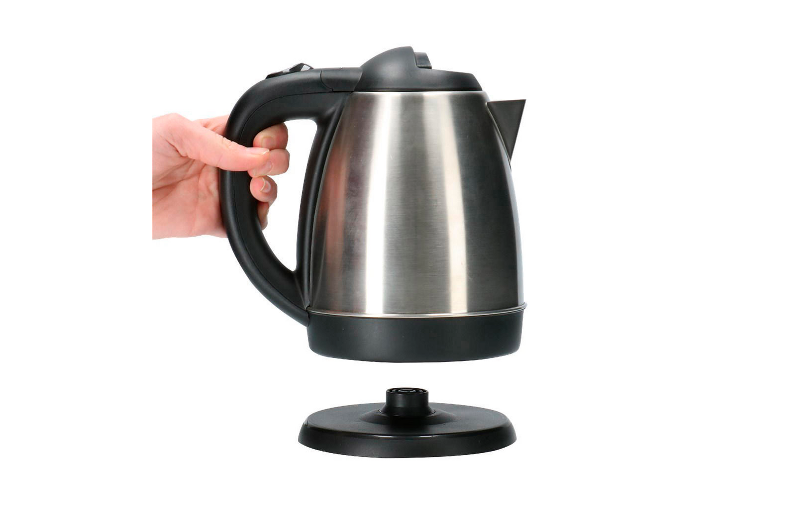 Hand holding an electric kettle above the base