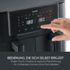 Schwarzes Küchengerät mit Touch-Display, zwei grün leuchtende '180'-Anzeigen, rechter Zeigefinger berührt das Display; darunter deutscher Text sichtbar