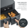 Graues Gerät mit digitalem Display und zwei geöffneten, herausziehbaren Schubladen; in den Schubladen Pommes und Hähnchenteile; Hände an den Griffen; sichtbarer Text: 'ZWEI GERICHTE GLEICHZEITIG 2 x 4-L-Garkörbe - noch mehr Platz für flexible & gleic