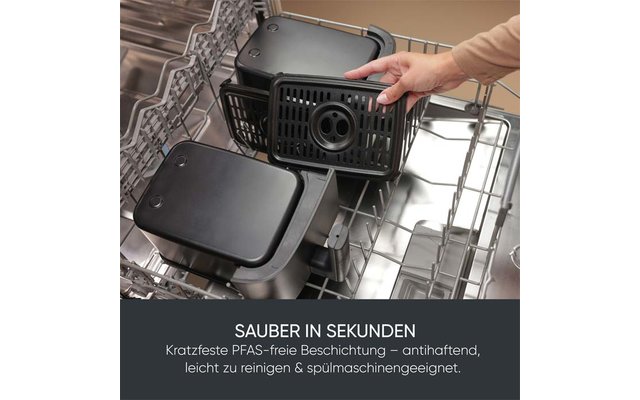 Innenraum einer geöffneten Spülmaschine mit zwei schwarzen rechteckigen Behältern mit Deckeln und einer Hand, die einen Behälter einsetzt