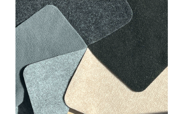 Mehrere überlappende, flache rechteckige Formen mit abgerundeten Ecken in Schwarz, Dunkelgrau, Hellgrau und Beige mit leichter Textur auf dunklem Hintergrund