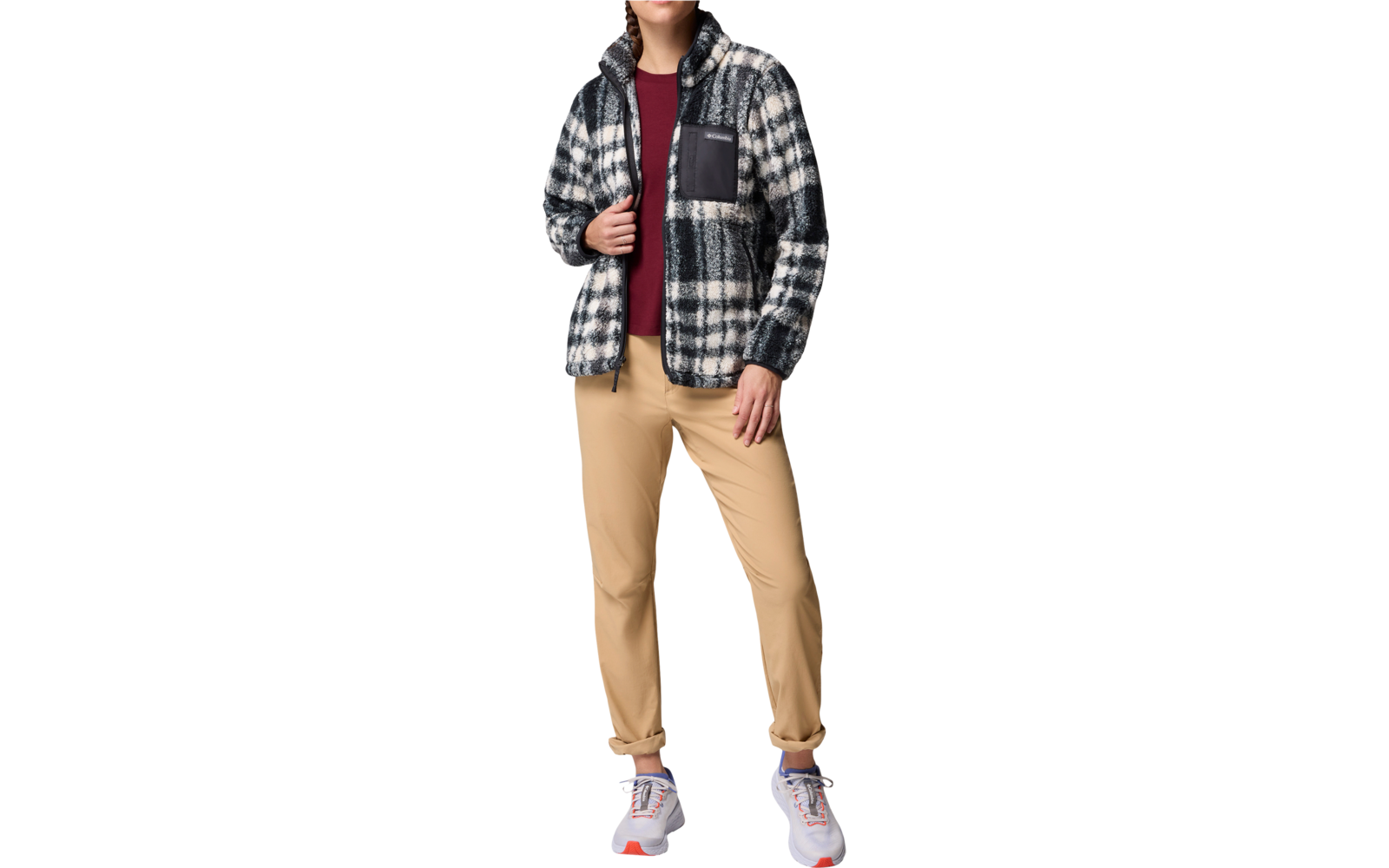 Ein Junge trägt eine karierte Jacke, ein rotes T-Shirt und eine beige Hose