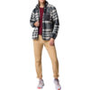 Ein Junge trägt eine karierte Jacke, ein rotes T-Shirt und eine beige Hose