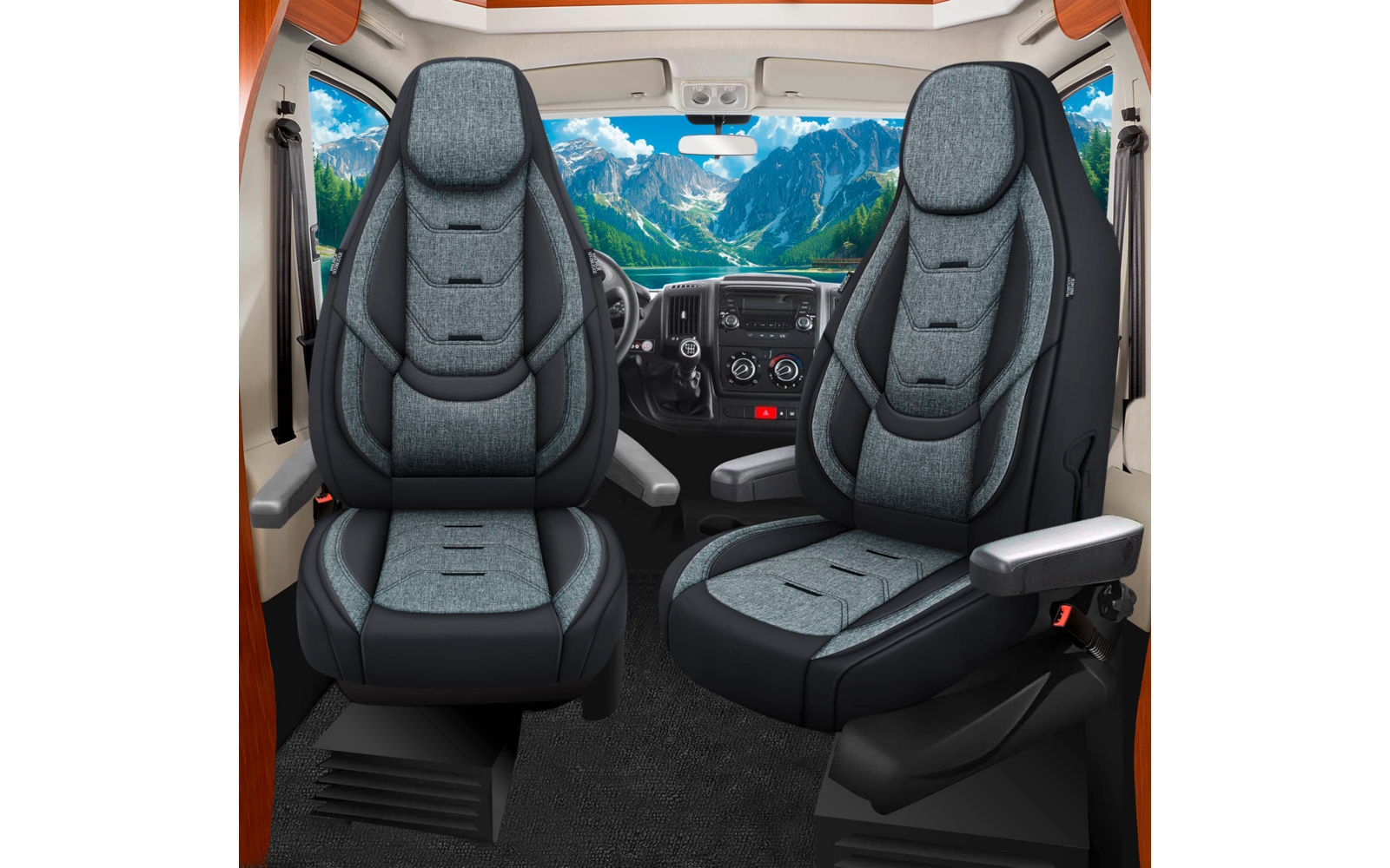 Fahrzeuginnenraum mit zwei vorderen Sitzen, Armlehnen und Armaturenbrett; durch Windschutzscheibe Berglandschaft mit Bäumen und blauem Himmel