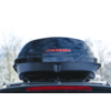 Baule da tetto nero lucido con logo rosso "KAMEI" montato sul portapacchi dell'auto, alberi sfocati sullo sfondo, luce posteriore di stop visibile