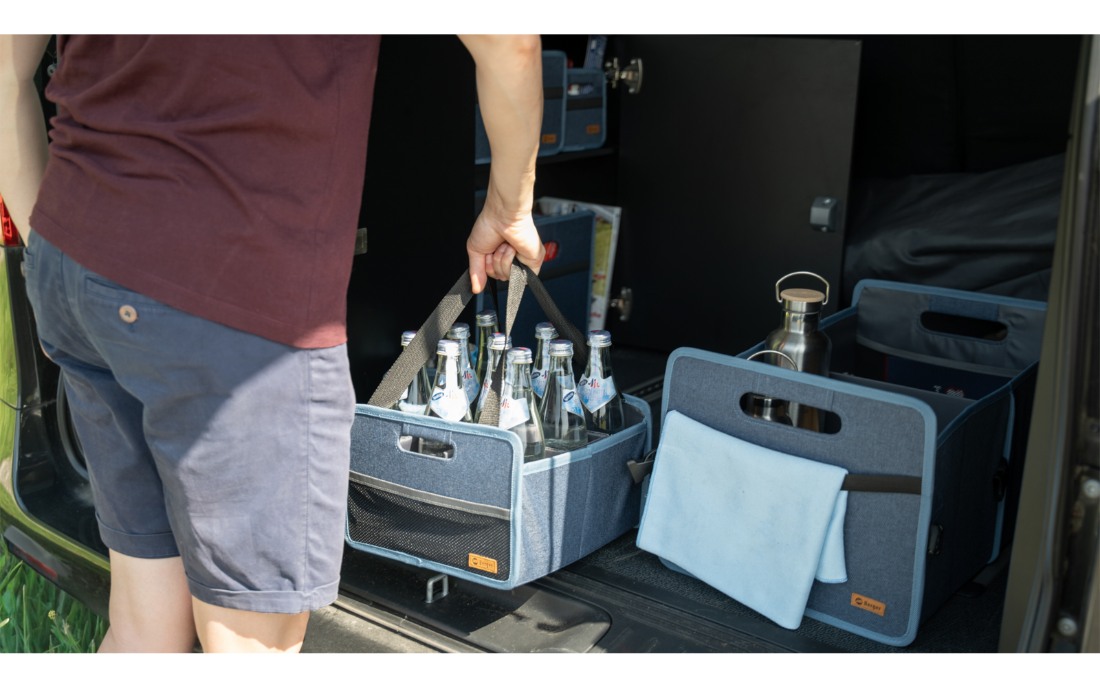 Personne remplissant des bouteilles à partir d'une caisse de boissons grise