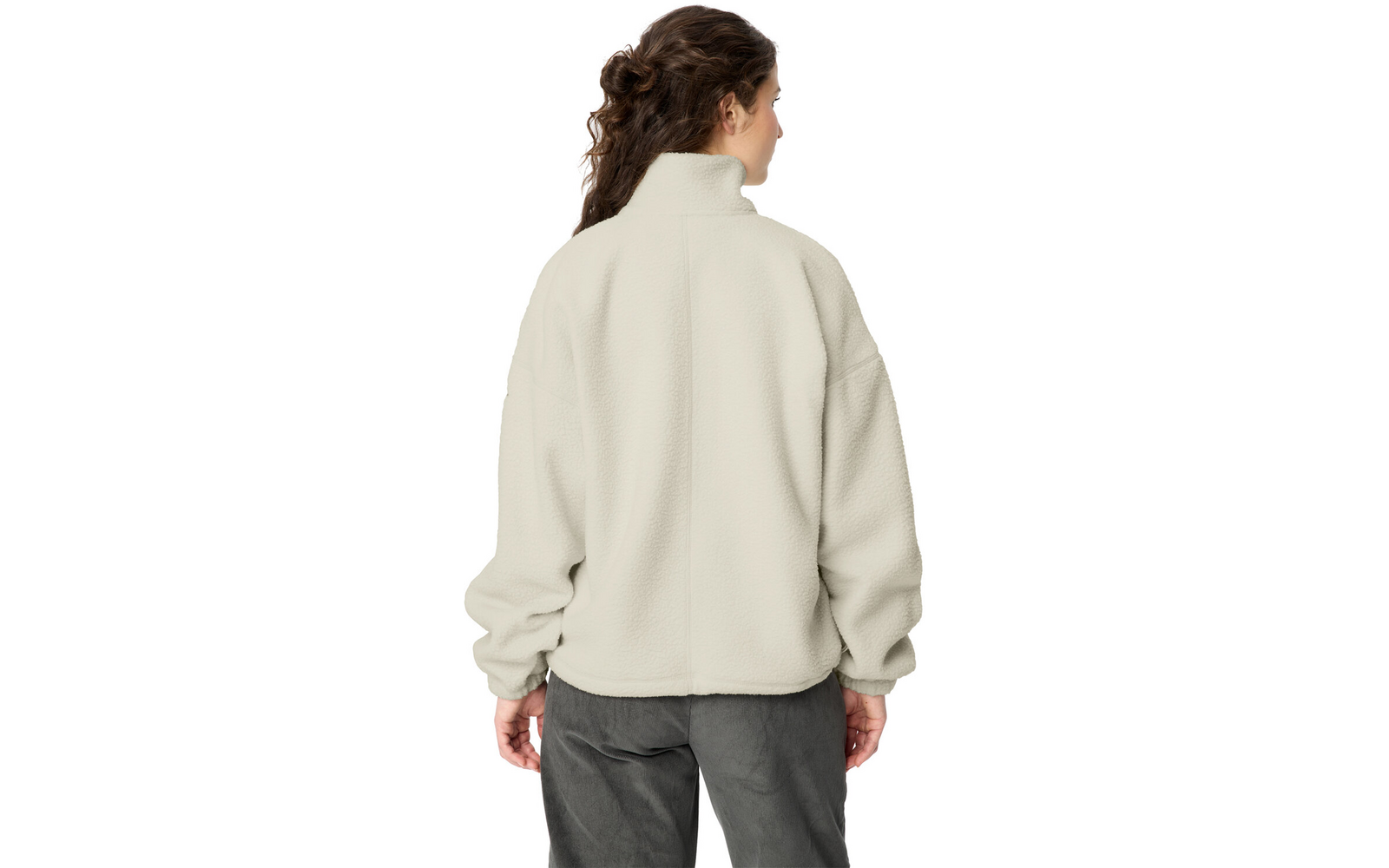 Person seen from behind wearing a light beige fleece jacket with a high collar and dark pants; brown wavy hair pulled back