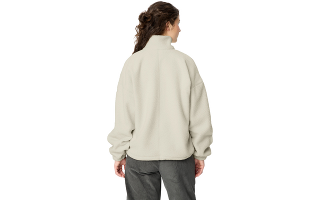 Person seen from behind wearing a light beige fleece jacket with a high collar and dark pants; brown wavy hair pulled back