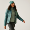 Frau mit grüner Mütze, grünem Pullover und türkisfarbener Steppjacke, die nach rechts schaut