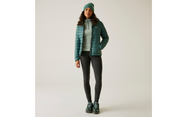 Frau trägt grüne Jacke, schwarze Leggings und grüne Sportschuhe
