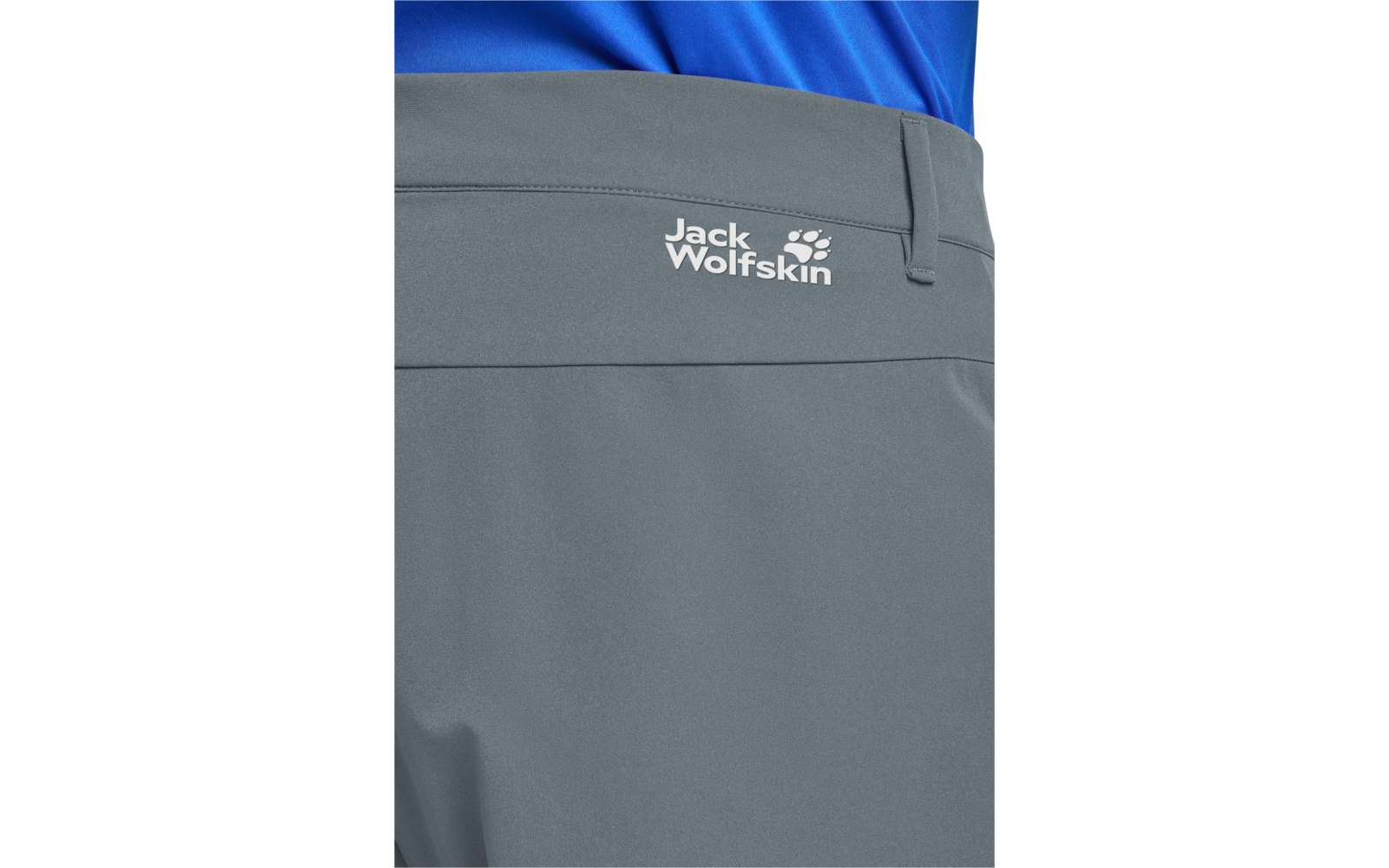 Close-up van de achterkant van een grijze broek met wit 'Jack Wolfskin'-logo boven een horizontale naad en een zichtbaar blauw bovenstuk