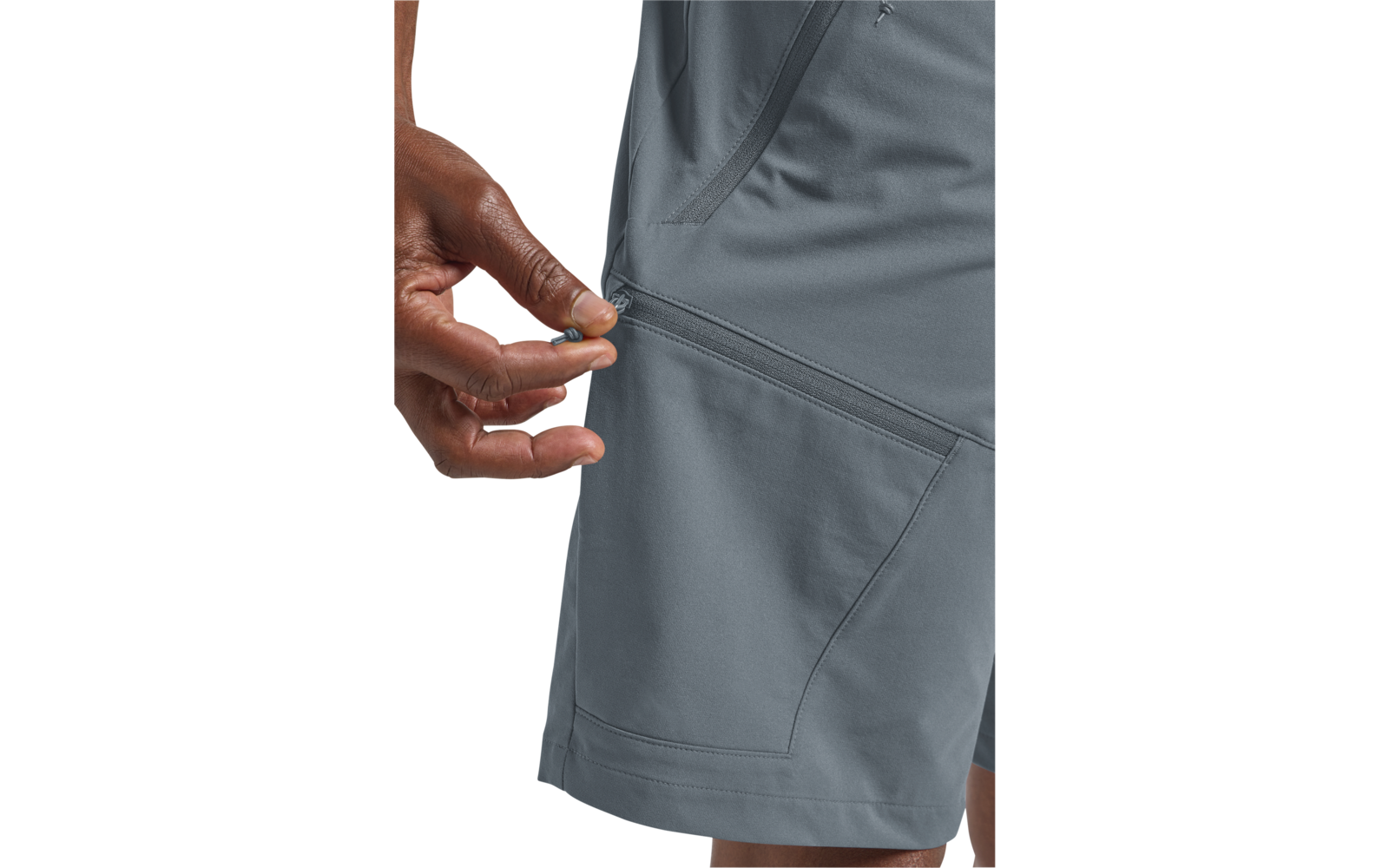 Hand trekt aan de rits van een grijze short