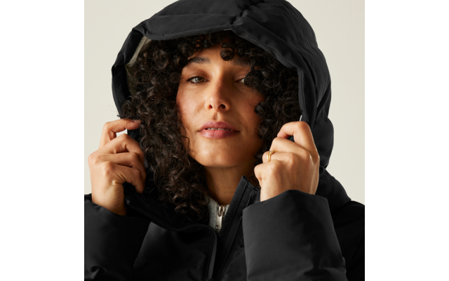 Frau mit lockigem Haar, die eine schwarze Kapuzenjacke anzieht