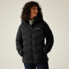 Frau mit lockigen Haaren trägt eine schwarze Winterjacke und lächelt