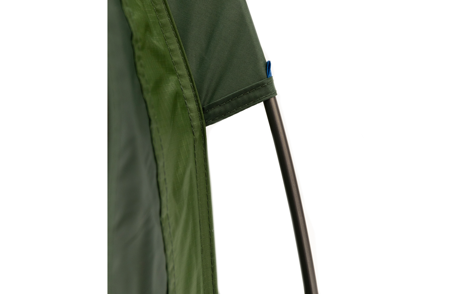 Nahaufnahme eines grünen Zeltstoffs mit eingenähter Stangentasche, darin ein gebogenes Metallgestänge und ein kleiner blauer Kunststoffclip sichtbar