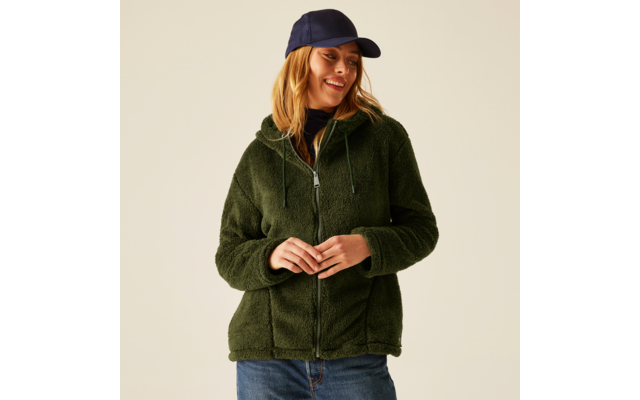 Frau trägt grüne Fleecejacke und blaue Jeans, sie trägt eine dunkelblaue Kappe