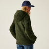 Person trägt grüne Kapuzenjacke und blaue Kappe, Blick nach links