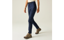 Onderlichaam van een persoon, alleen benen en heupen zichtbaar; donkerblauwe broek, beige-bruin veterschoenen met profielzool; lichte achtergrond