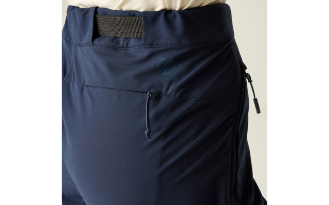 Close-up van het heupgedeelte in een donkerblauwe broek met elastische taille, zijritszak, koord en een lichtgekleurde bovenkant zichtbaar bovenaan