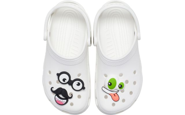 Paire de sabots blancs vue de dessus. Sabot gauche avec décorations clipsées : lunettes noires et moustache, et décoration de bouche rose. Sabot droit avec décoration d'œil vert et décoration de langue tirée