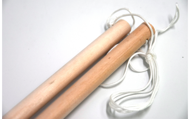 Holzstäbe mit weißen Schnüren auf weißem Hintergrund