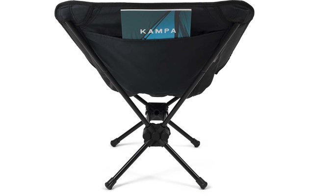 Schwarzer klappbarer Campingstuhl mit gekreuzten Metallbeinen und Stoffsitz, in der Tasche des Stuhls ein Heft mit dem Schriftzug "KAMPA"