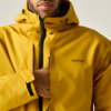 Teilansicht von Kinn und Oberkörper einer Person in gelber Kapuzenjacke mit Reißverschluss, sichtbarem Markenlogo „Regatta“ und einer Hand in der Brusttasche