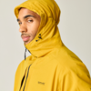 Person in gelber Kapuzenjacke, Seitenansicht, Blick zur Kamera, heller Hintergrund