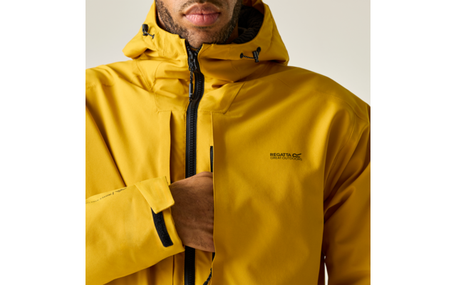 Teilansicht von Kinn und Oberkörper einer Person in gelber Kapuzenjacke mit Reißverschluss, sichtbarem Markenlogo „Regatta“ und einer Hand in der Brusttasche