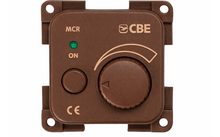 Pannello quadrato marrone con quattro fori di fissaggio, LED verde accanto alla scritta 'ON', piccolo pulsante rotondo a sinistra, grande manopola rotante a destra con una freccia, segni curvi sopra la manopola, 'CBE' in alto a destra, 'MCR' in alto a sinistra e 'CE' in basso a sinistra