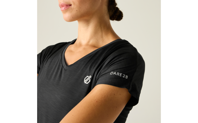 Oberkörper einer Person in schwarzem V‑Neck-Sportshirt mit weißem Logo auf der Brust und Schriftzug 'DARE28' auf dem Ärmel; Haar zu einem Dutt gebunden