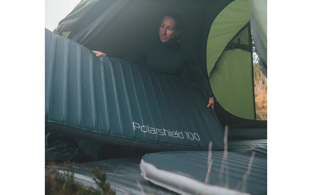 Person liegt auf einer aufblasbaren Isomatte unter einem Zeltdach