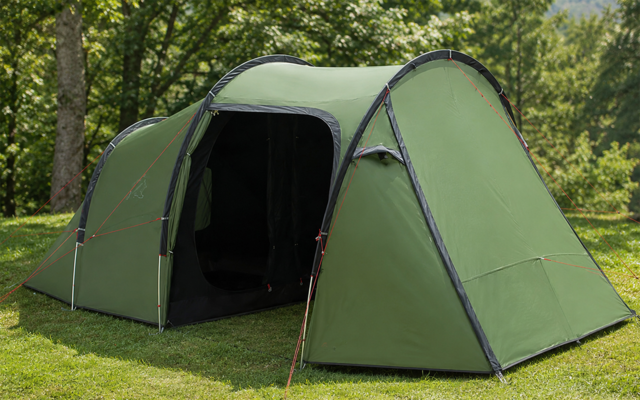 Groene tent op gras met een open ingang en bomen op de achtergrond