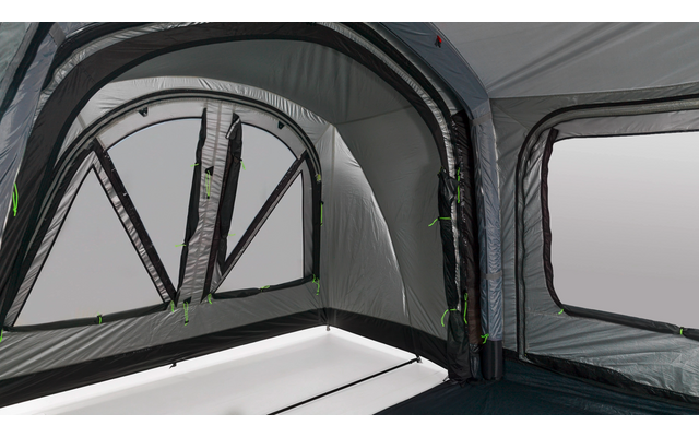 Interno di una tenda gonfiabile grigia con due grandi aperture finestra, inserti finestra trasparenti, cerniere visibili con tiretti verdi e pavimento scuro