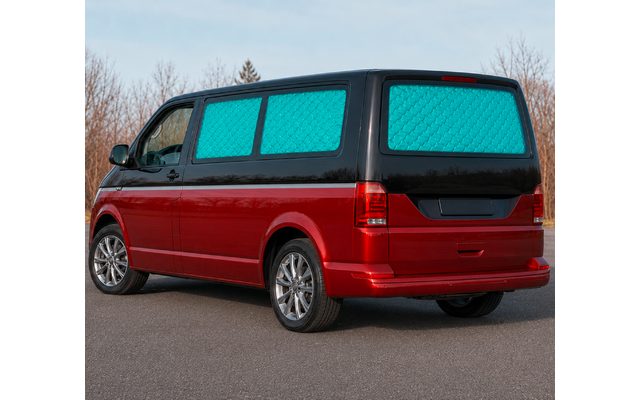 Red van, blue quilted window covers, parked on a road; leafless trees and sky in the background