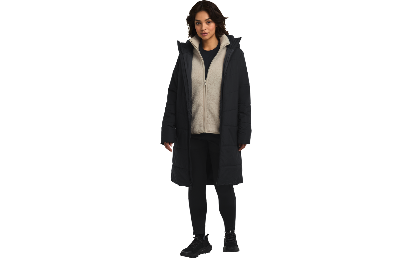 Frau mit dunklem langen Mantel, beiger Kapuzenpullover und schwarzer Hose